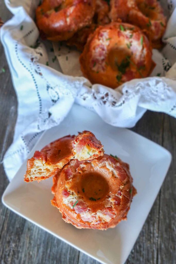 baked cheese and bacon donut cut in half on a small plate