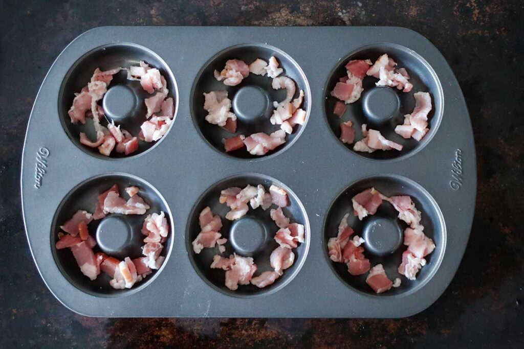 donut pan lined with chopped uncooked bacon