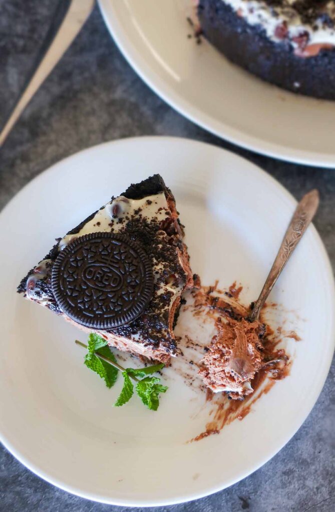 slice of chocolate cheesecake on a plate topped with oreo cookie
