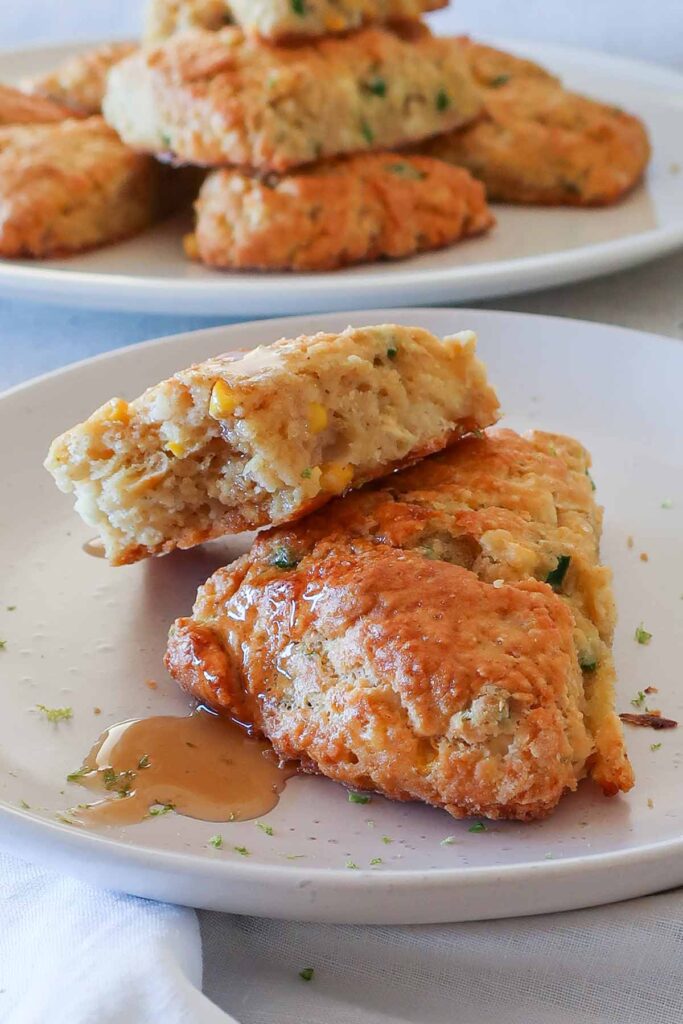 jalapeno corn feta scones on a plate drizzled with maple syrup