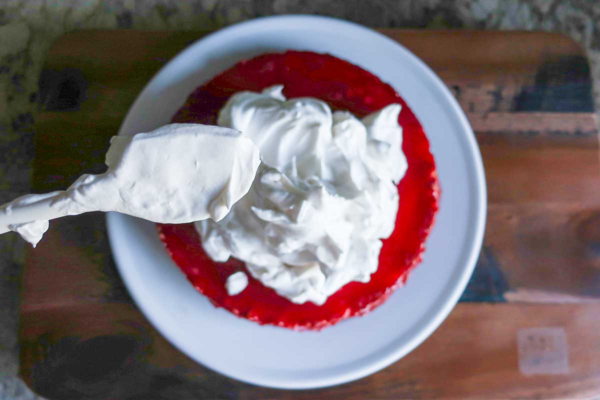 spreading whipped egg whites over cranberry layer 