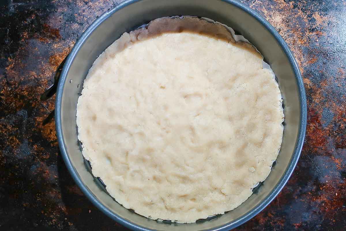 almond crust in a springform pan before baking