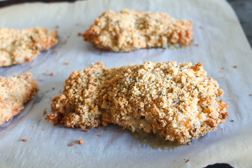 a piece of oven-fried buttermilk chicken on parchment paper