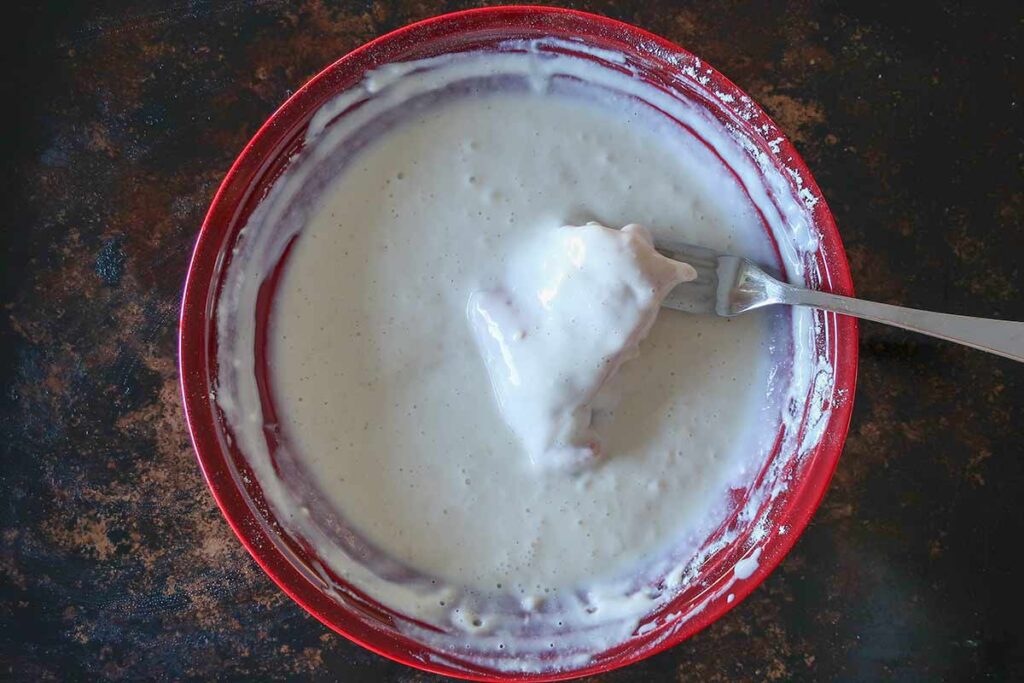 chicken coated in a pasty buttermilk mixture in a bowl