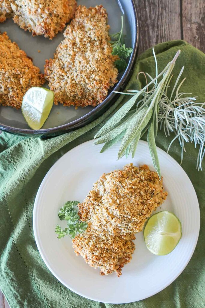 a piece of oven-fried buttermilk chicken on a plate with lime wedge