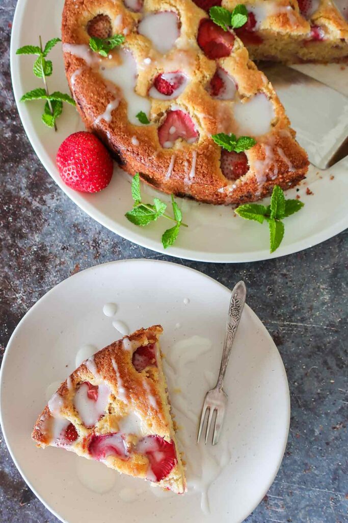 a slice of strawberry cake with buttermilk glaze on a plate