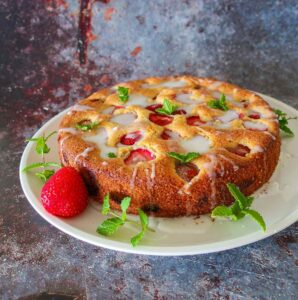 gluten free strawberry buttermilk cake on a platter with mint garnish