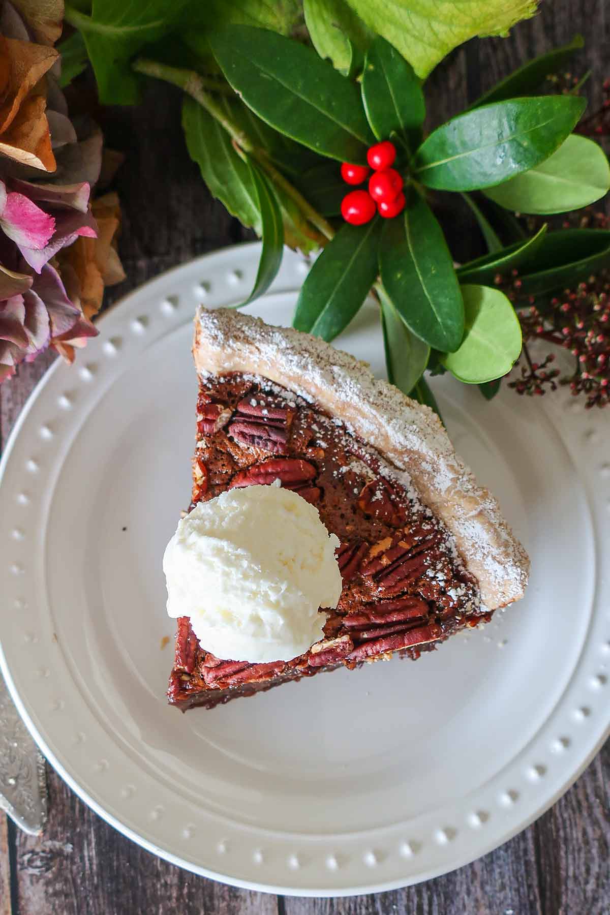 chocolate pecan pie on a plate with a scoop of ice cream