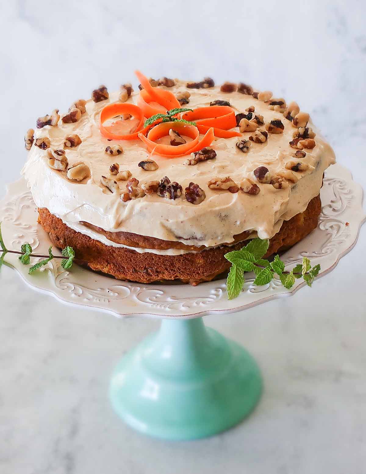 whole gluten free frosted pumpkin carrot cake on a dessert plate