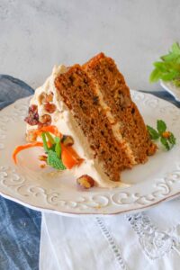 slice of pumpkin carrot cake with pumpkin cream cheee frosting on a plate