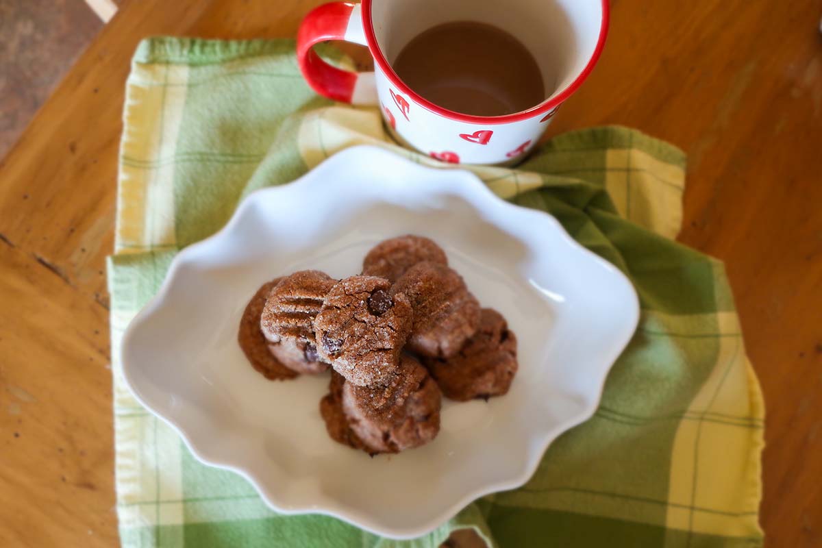 almond butter chocolate chip cookies on a plate with a cup of coffee