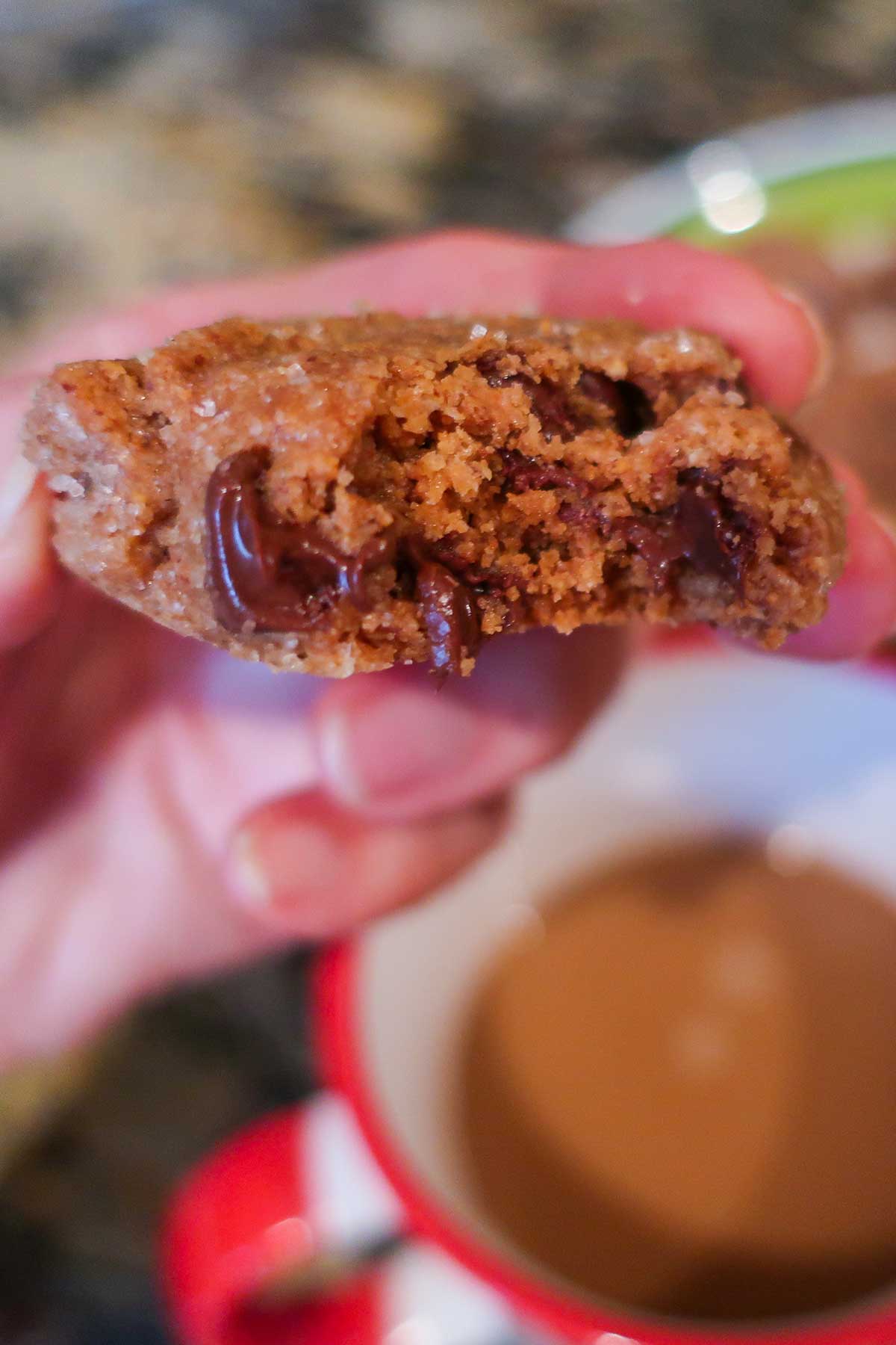 holding half an almond butter chocolate chip cookie