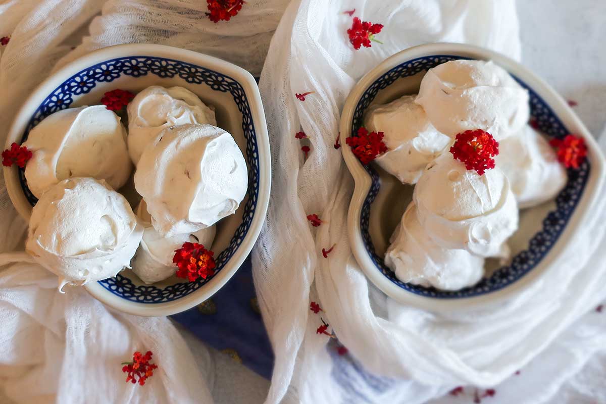 meringue cookies stacked in two bowls