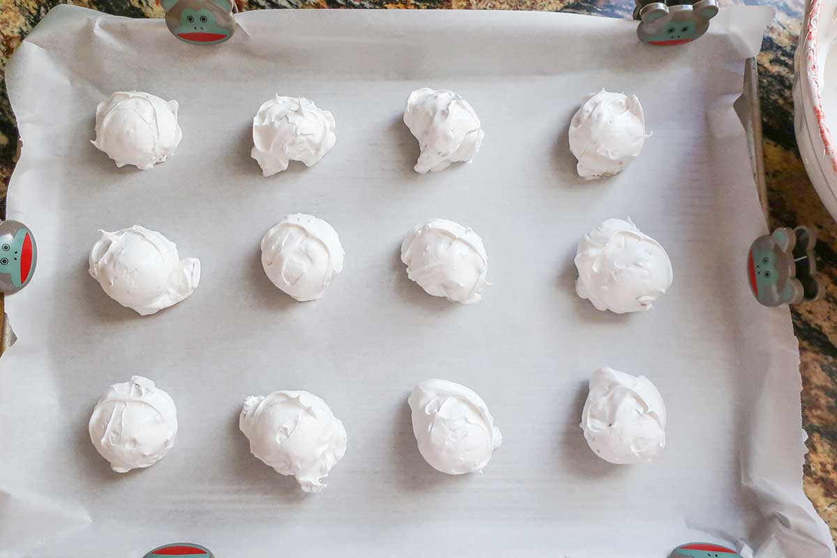 dollops of meringue on a baking sheet before baking