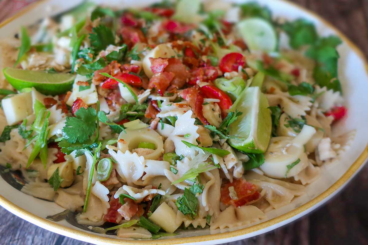 tomatoes, hearts of palm, cilantro and cheese with pasta in a bowl