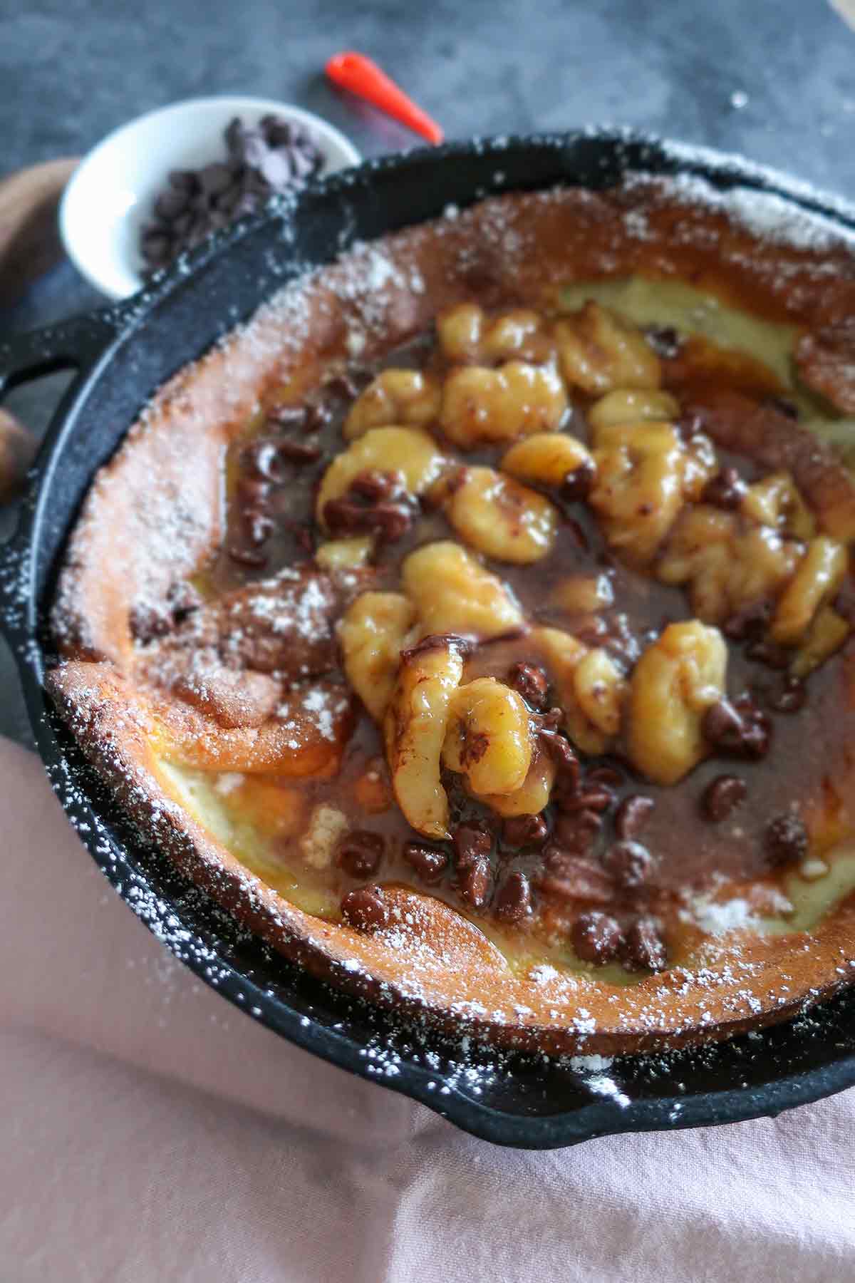 Chocolate Banana Foster Dutch Baby in a skillet close up 