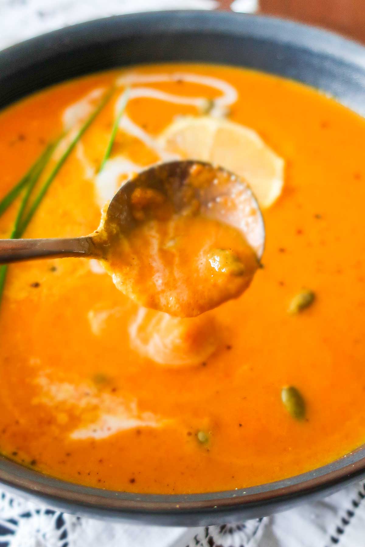 thick coconut carrot soup dripping from a spoon