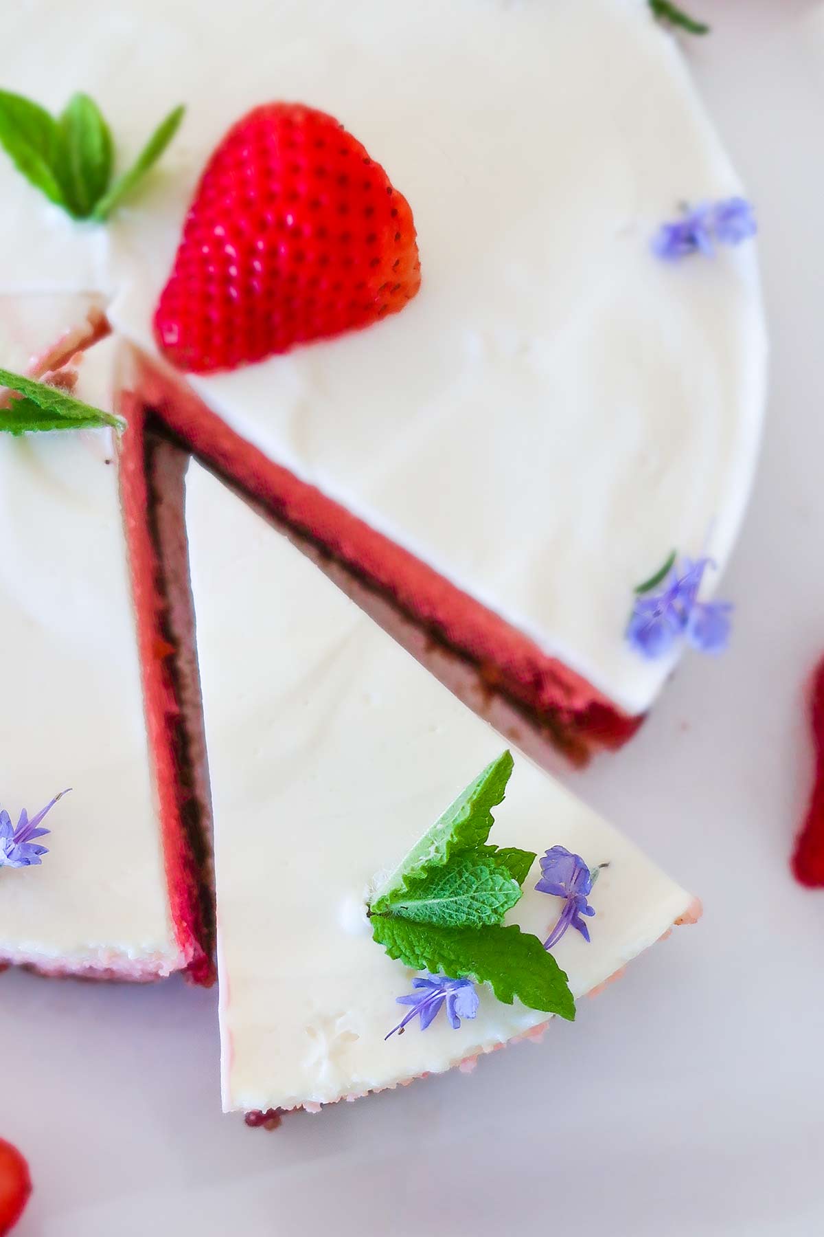 one slice cut out of a strawberry cheesecake