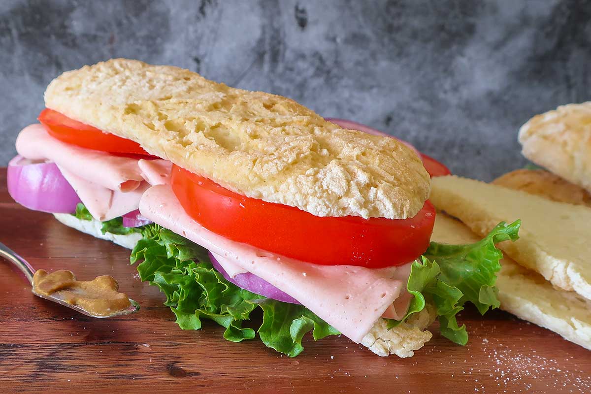 submarine sandwich filled with ham, tomato, onions and lettuce
