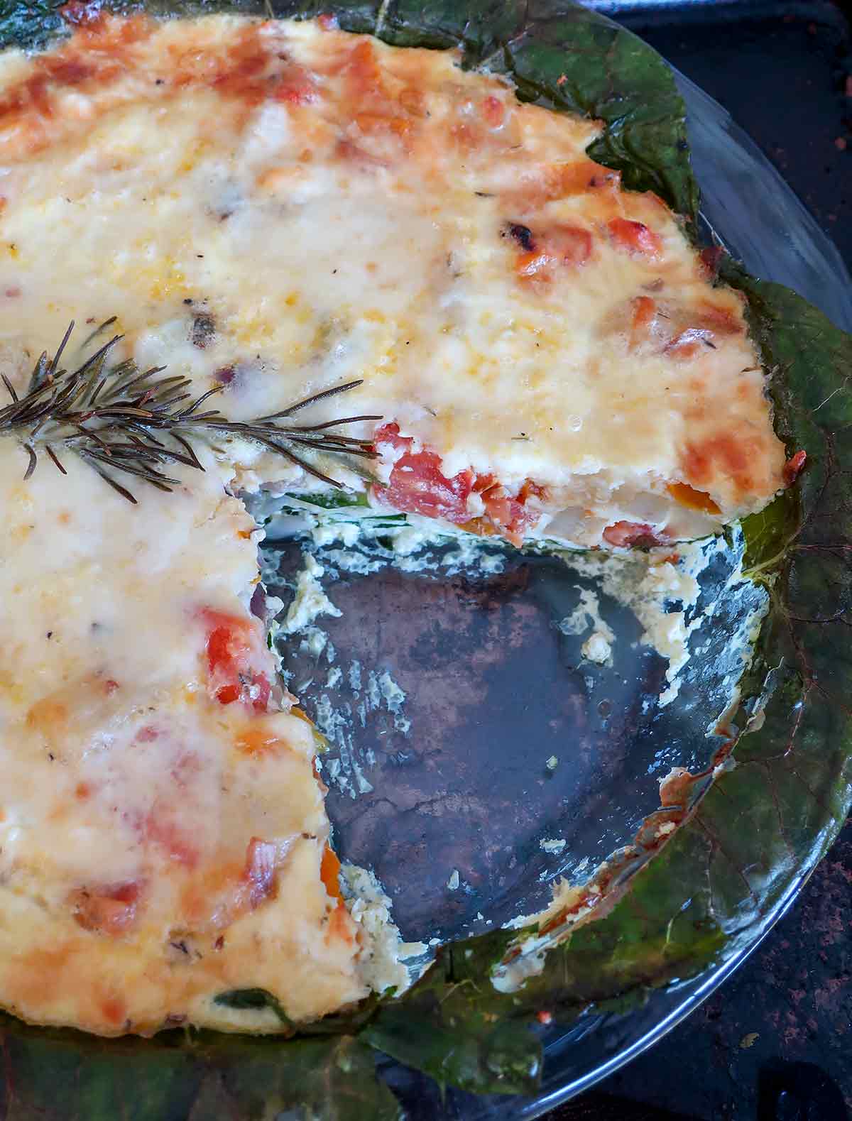 whole baked veggie pie missing a slice in a pie dish