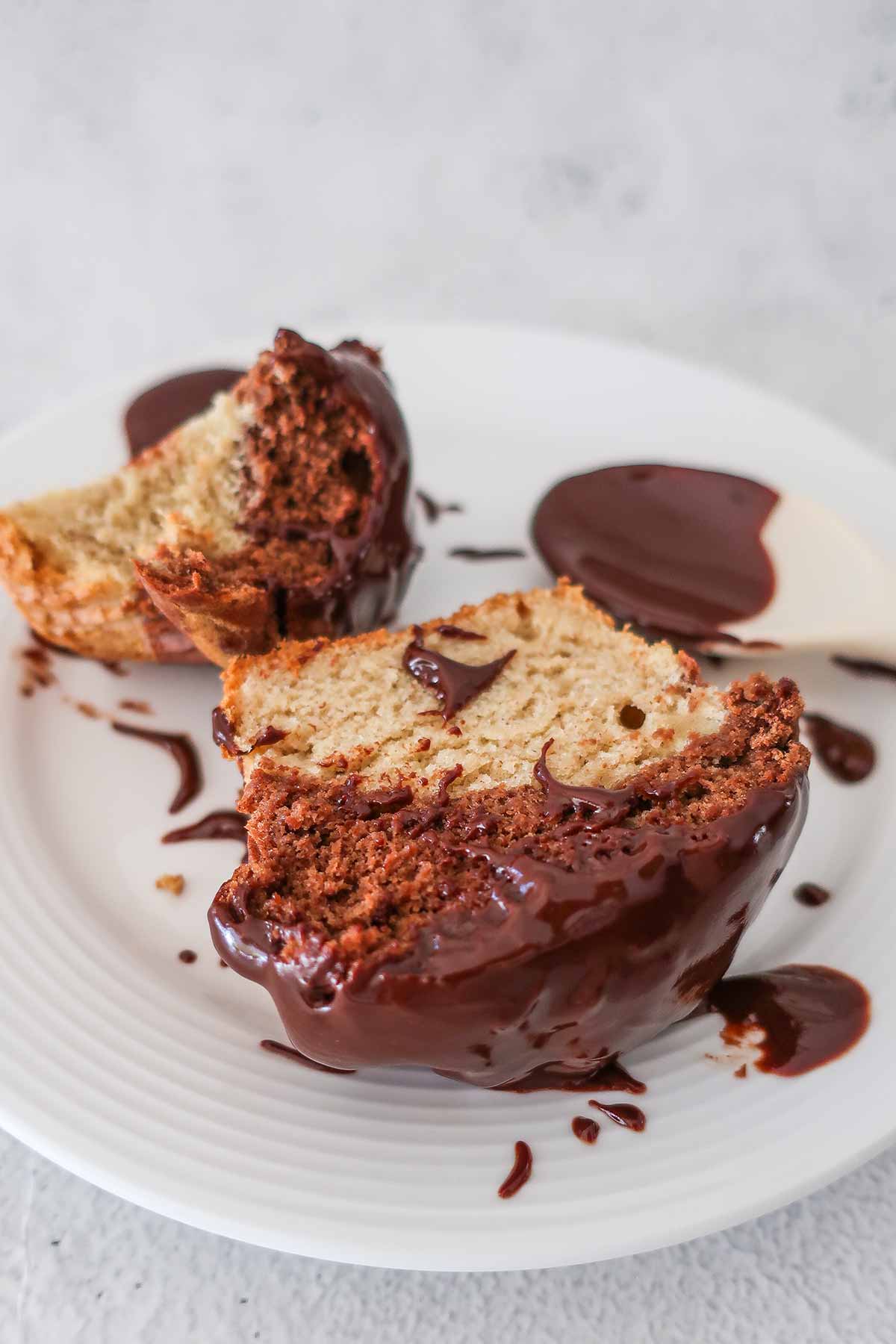 halved banana muffin with chocolate drizzle all over on a plate