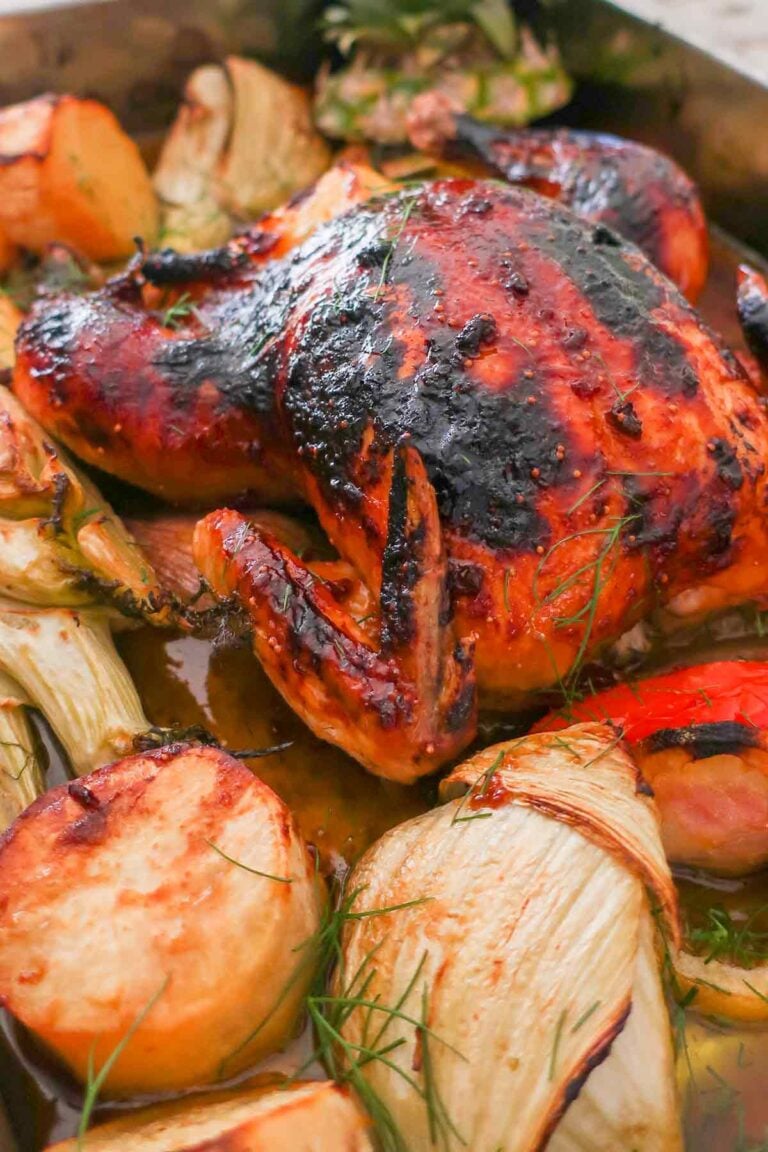 pineapple glazed roast chicken with veggies in a roasting pan