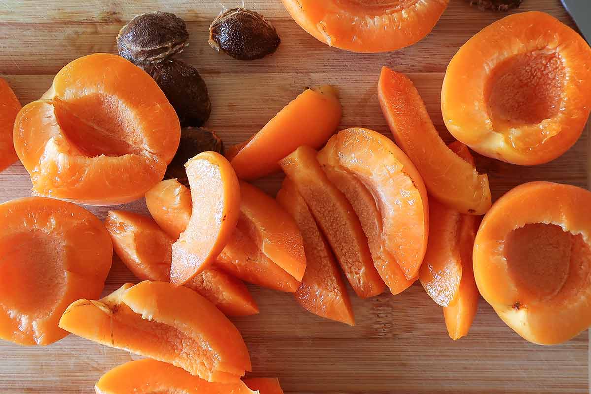 sliced fresh apricots on a wooden cutting board