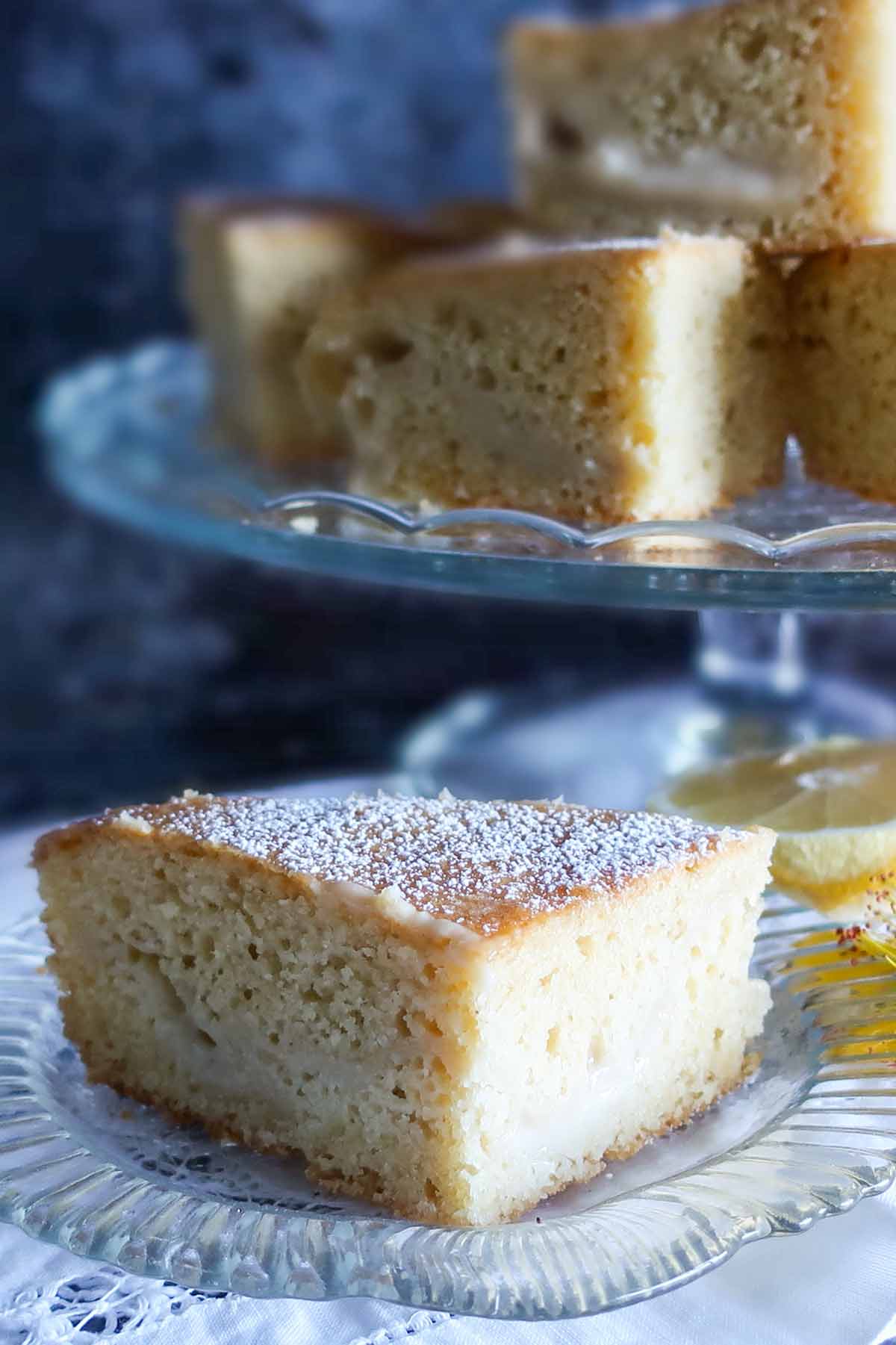 close up of vanilla cake dusted with powdered sugar on a plate