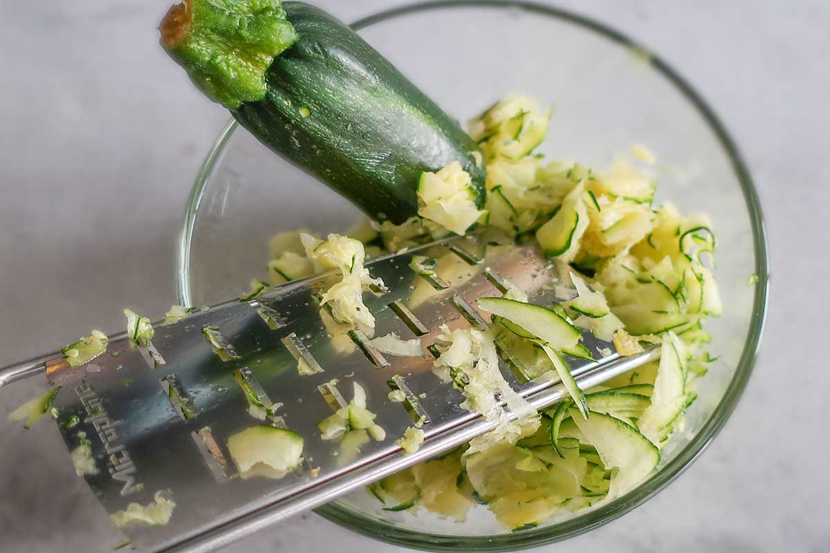 grating zucchini in a bowl