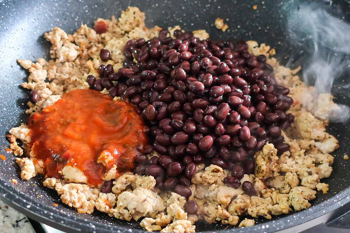 cooked ground chicken, black beans and splash of tomato sauce in a skillet