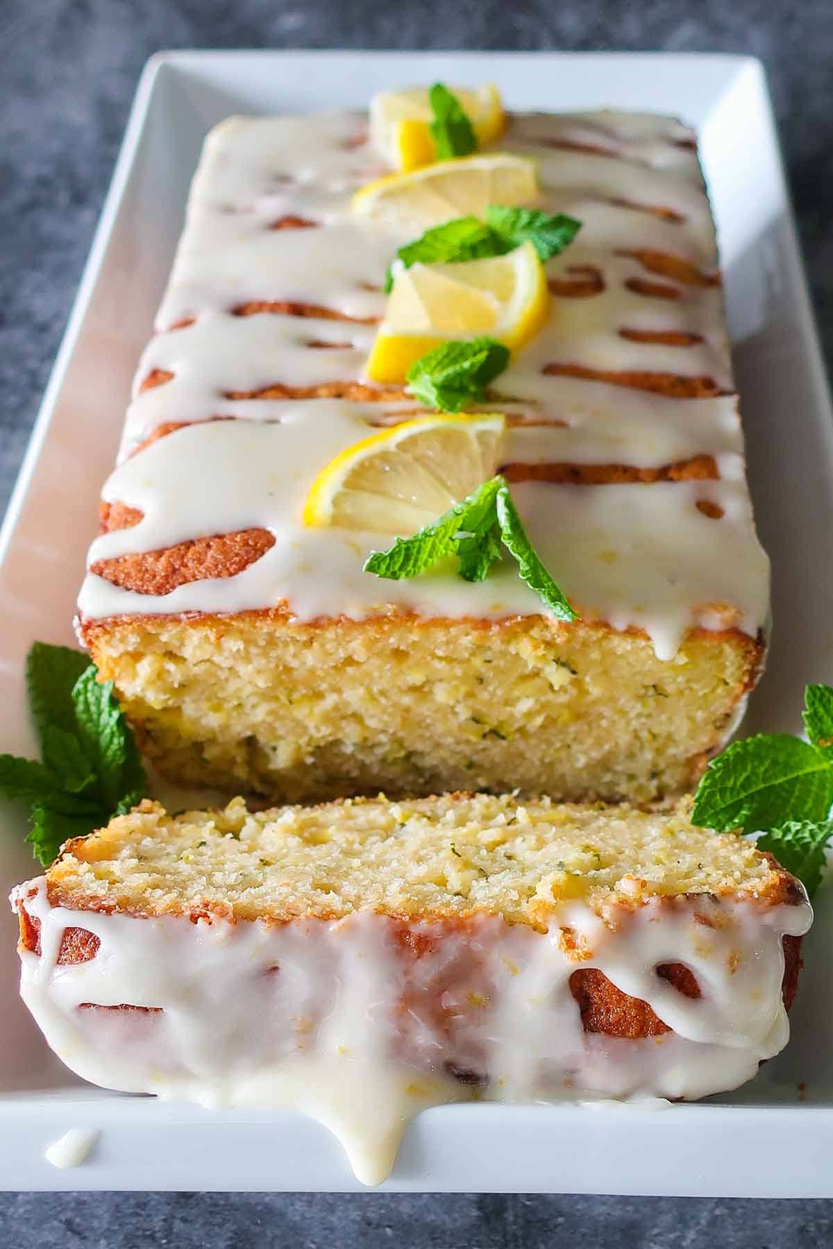 zucchini lemon rice flour loaf with icing and lemon slices