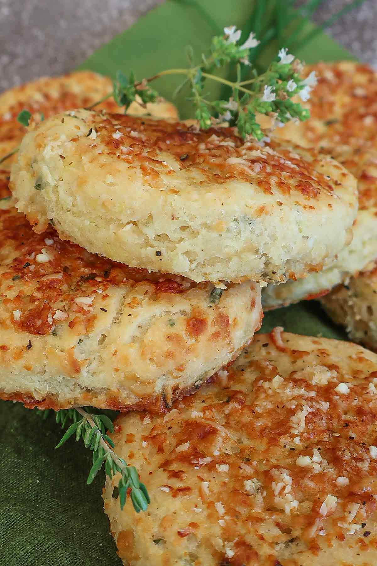 stack of 3 sweet potato parmesan biscuits topped with fresh herbs