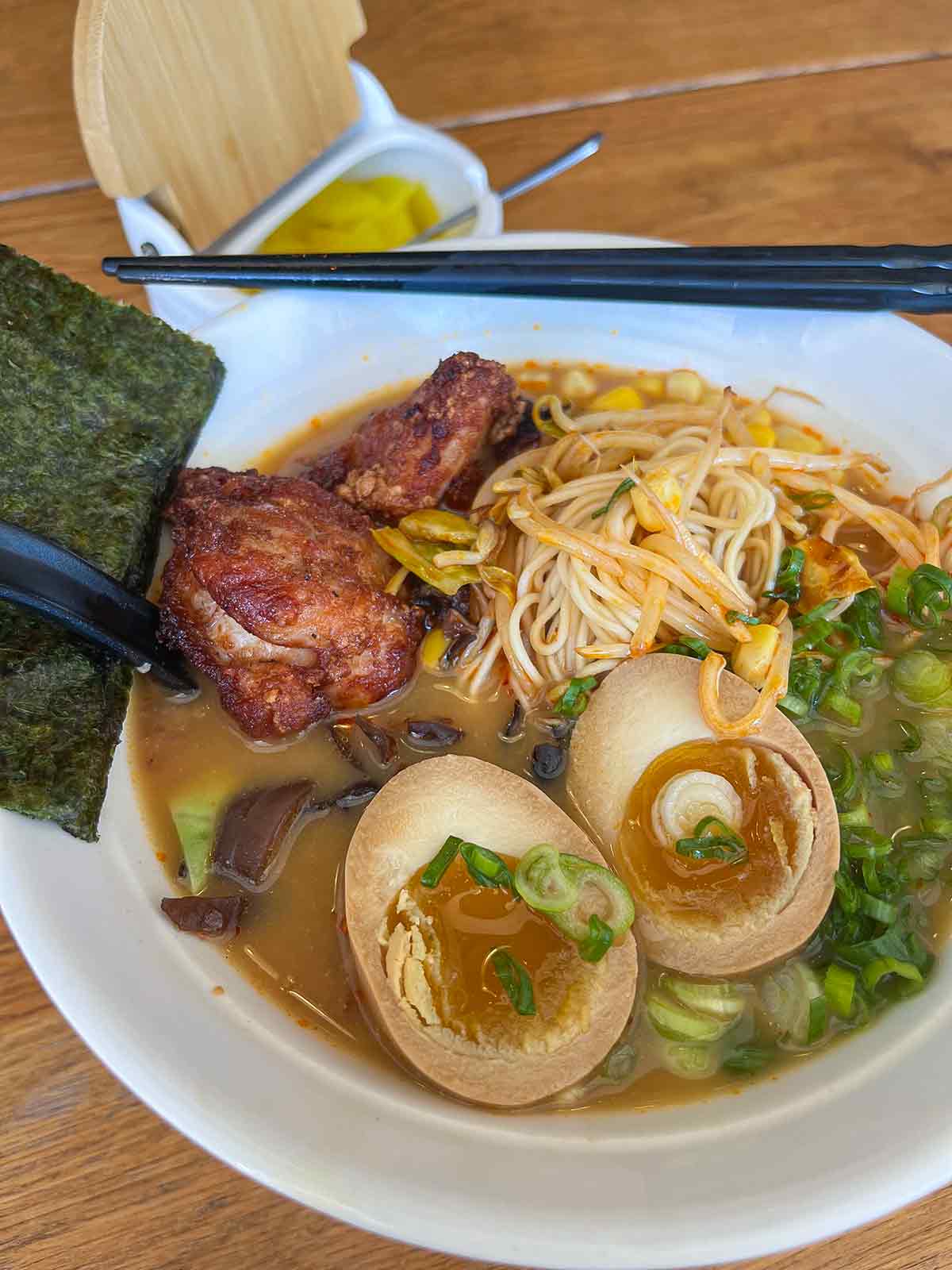 a bowl of ramen soup with chicken karaage, seaweed and green onions