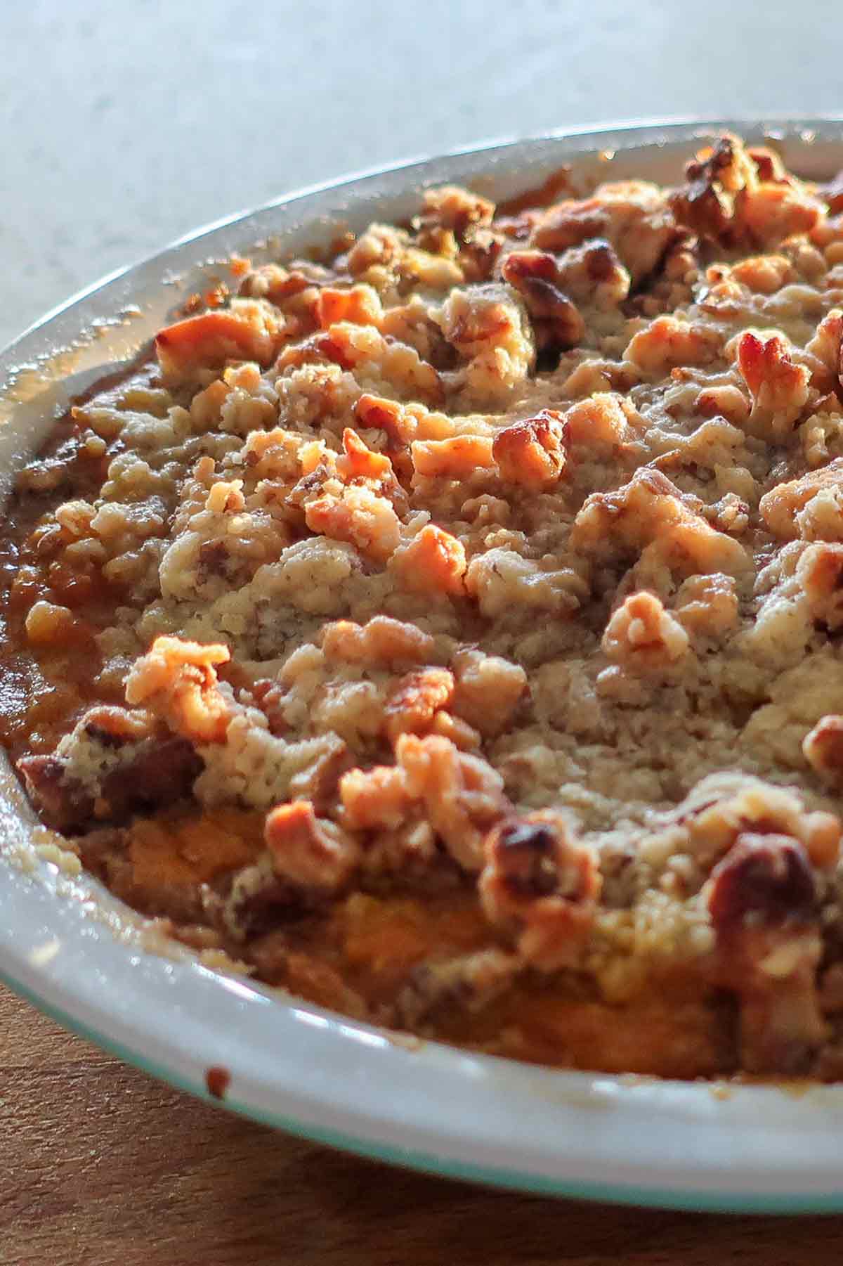 close up of whole baked apple pumpkin pie crisp with walnut topping