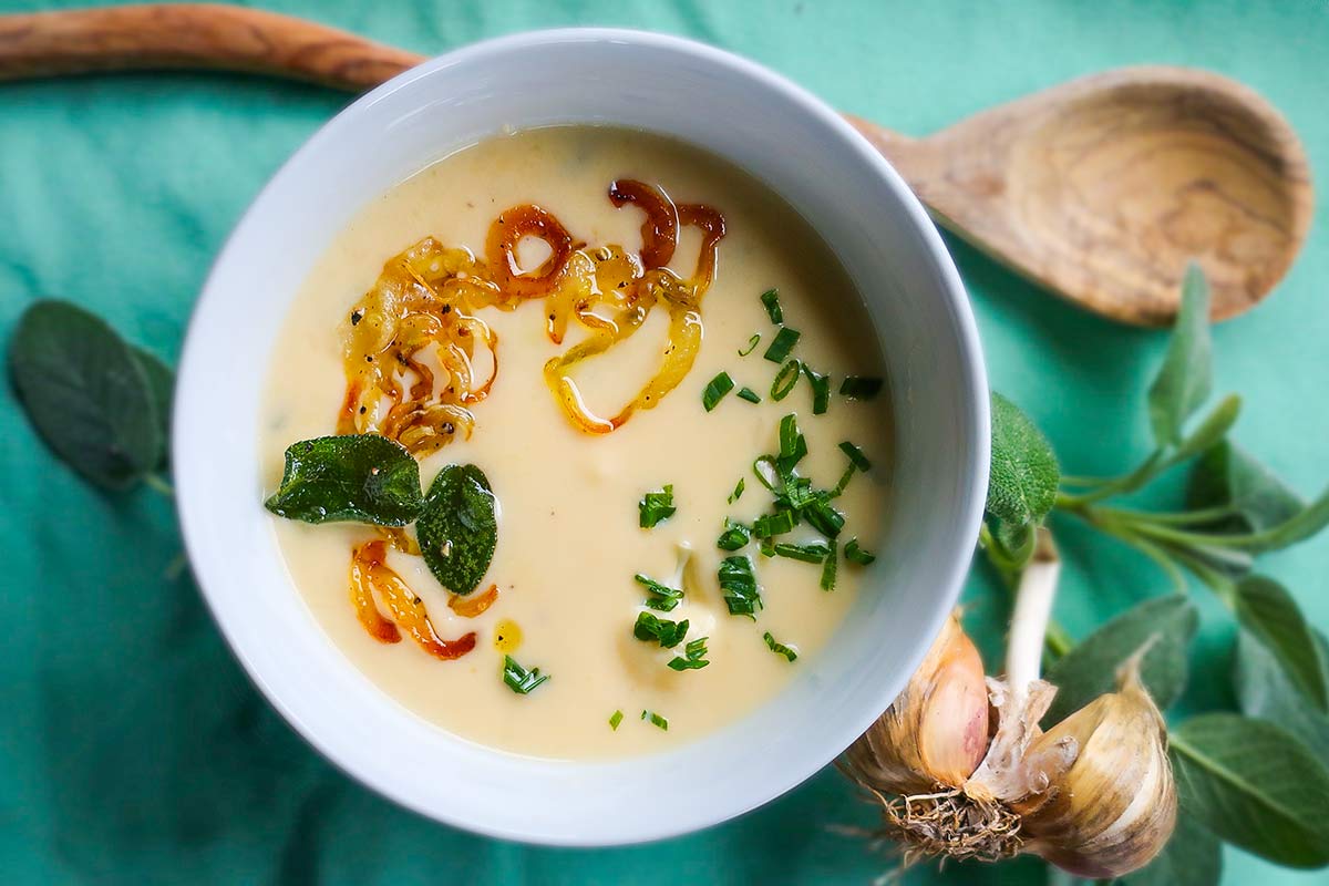 cheesy cauliflower soup in a bowl with toppings