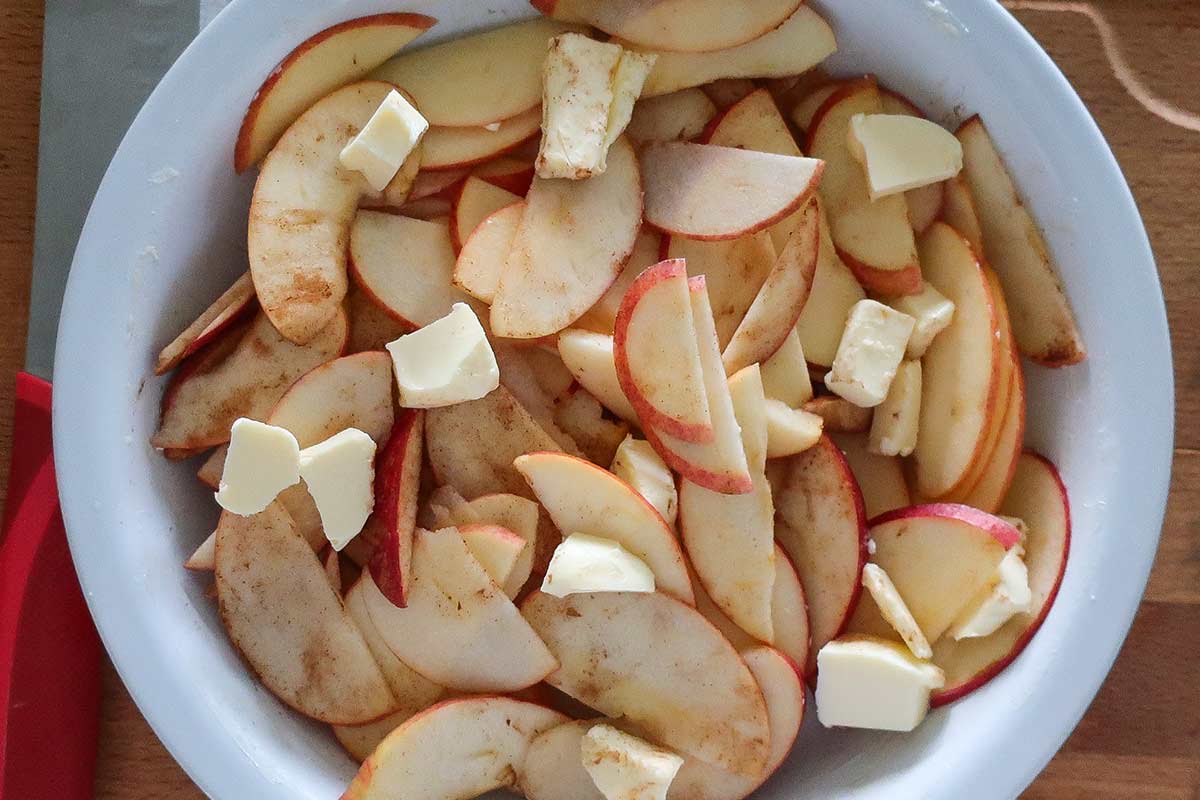 sliced apples with cinnamon in a pie dish