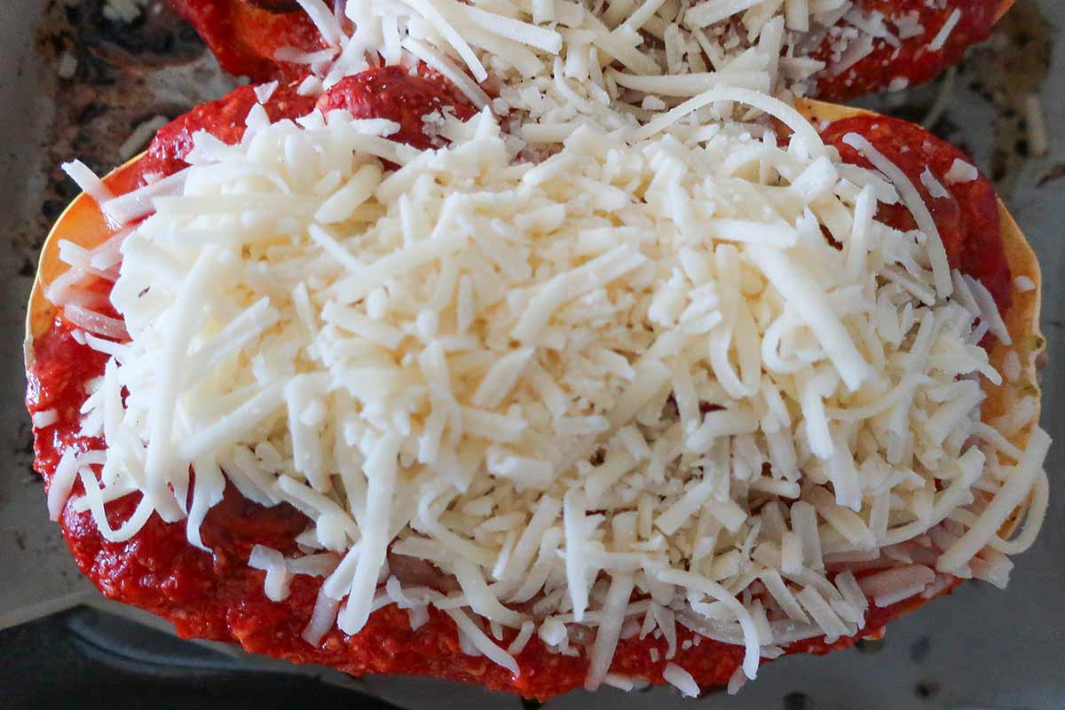 assembled squash boats filled with meatballs, sauce and topped with cheese before baking