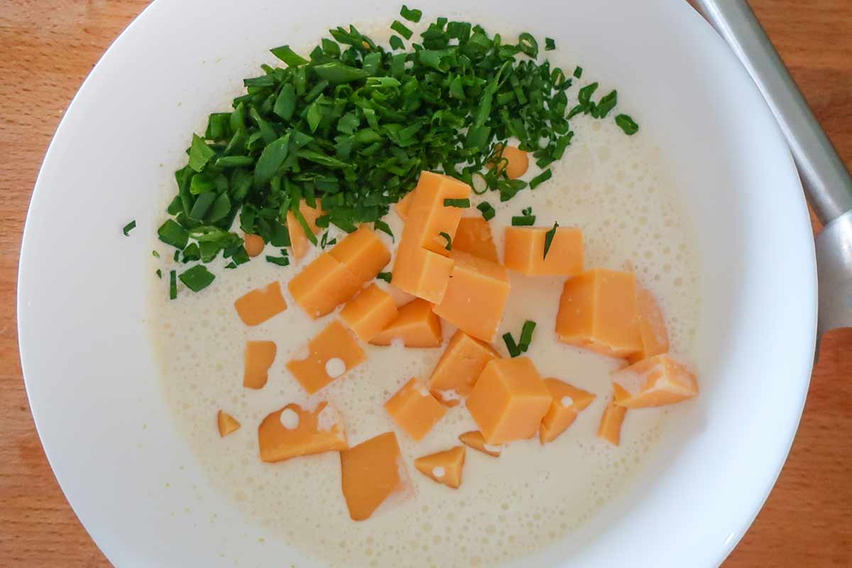 cream, chives and cubed cheddar in a bowl