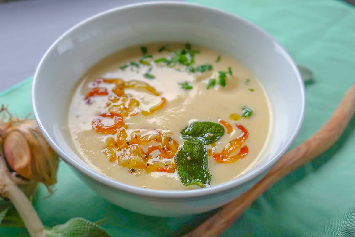 close up of toppings on top of the cauliflower soup in a bowl