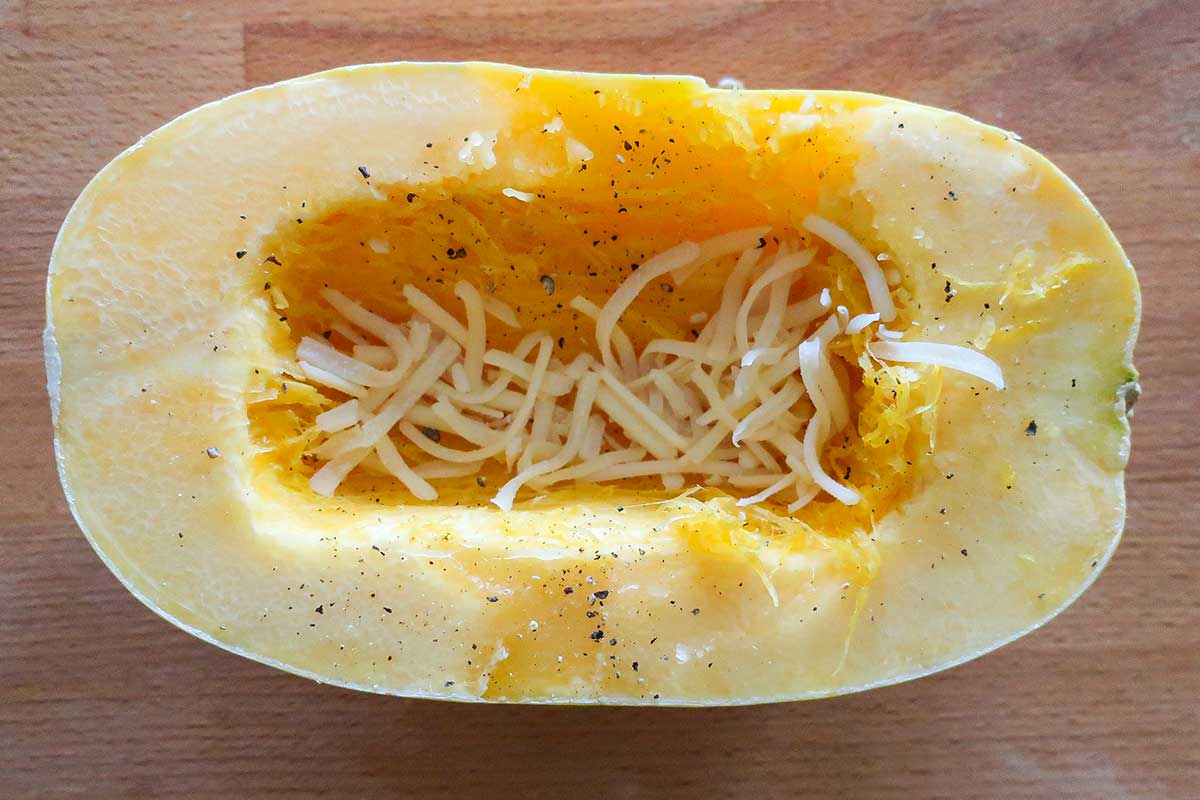 uncooked half a spaghetti squash sprinkled with cheese