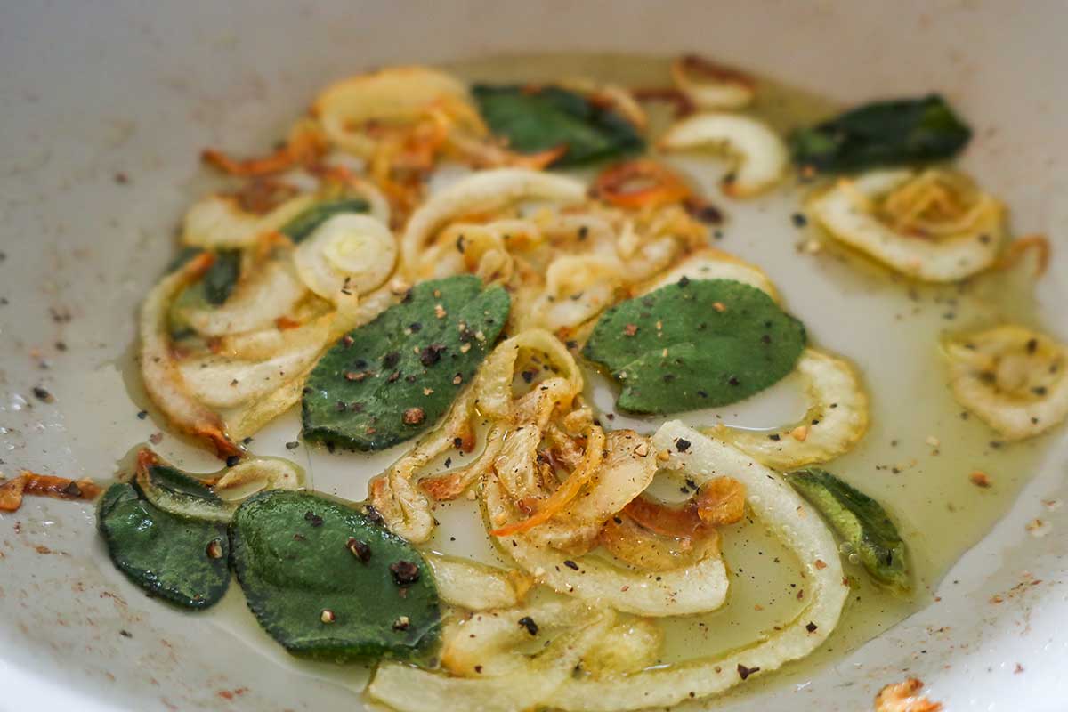 frying sage and onions in a skillet