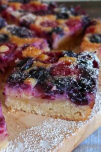 slice of lemon berry pudding cake dusted with powdered sugar