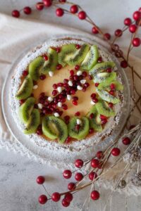 grain-free eggnog cheesecake decorated with kiwi and pomegranate