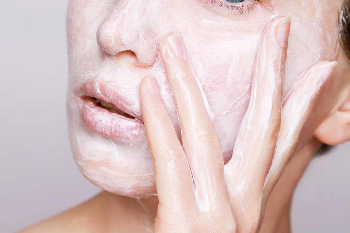 girl moisturizing her face with cream