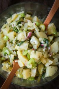 potato salad with pickles, celery, capers, dill and vinaigrette in a bowl