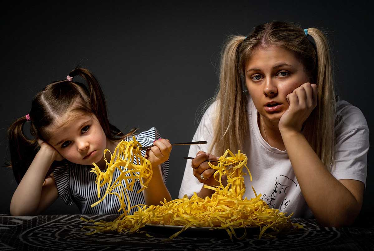 2 girls eating gluten free noddles