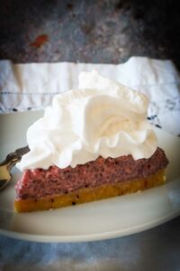 slice of no bake berry chia cake topped with cream