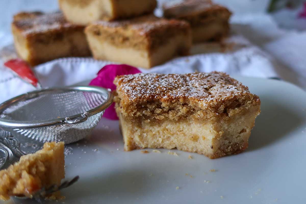 slice with one missing bite of grain free banana custard cake showing custard in the center