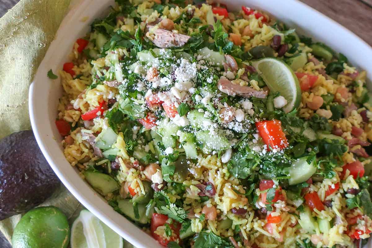 Mexican beef and rice salad with veggies and fresh herbs in a serving dish.