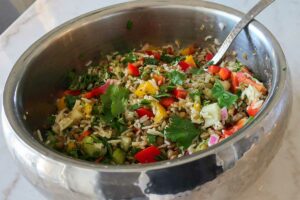 lentil and rice mixed with veggies, herbs and a light vinaigrette in a bowl